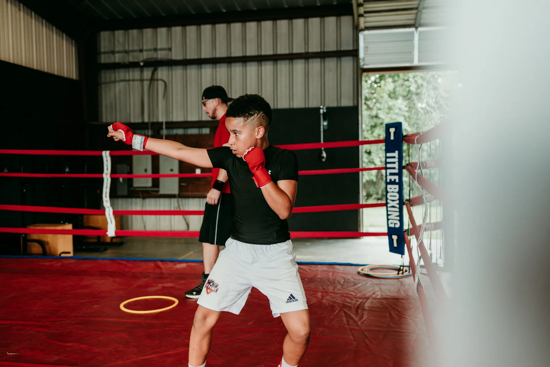 Young boxer throwing a jab inside the ring at One More Round Boxing Gym