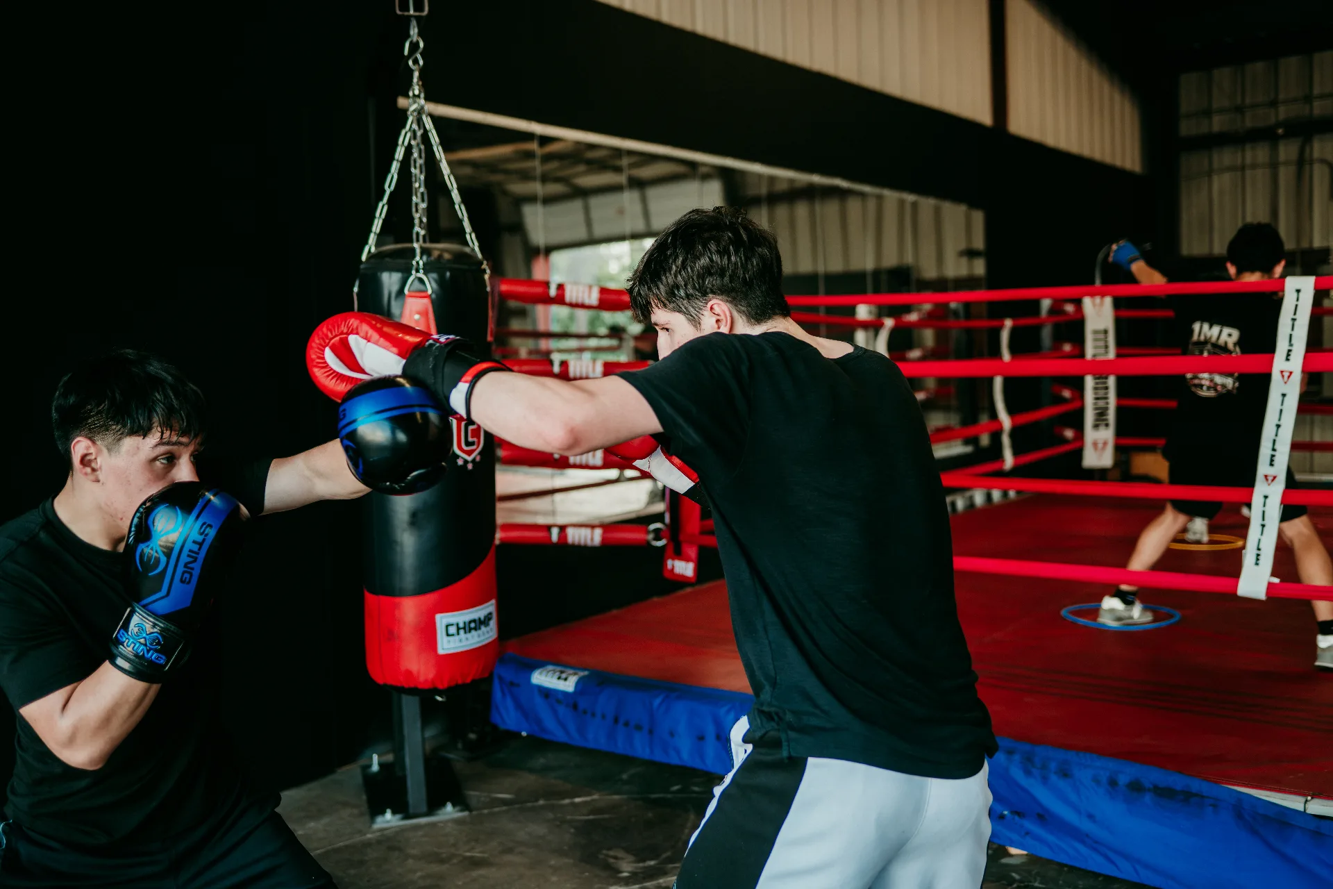 Two boxers working mitts and timing drills near the ring