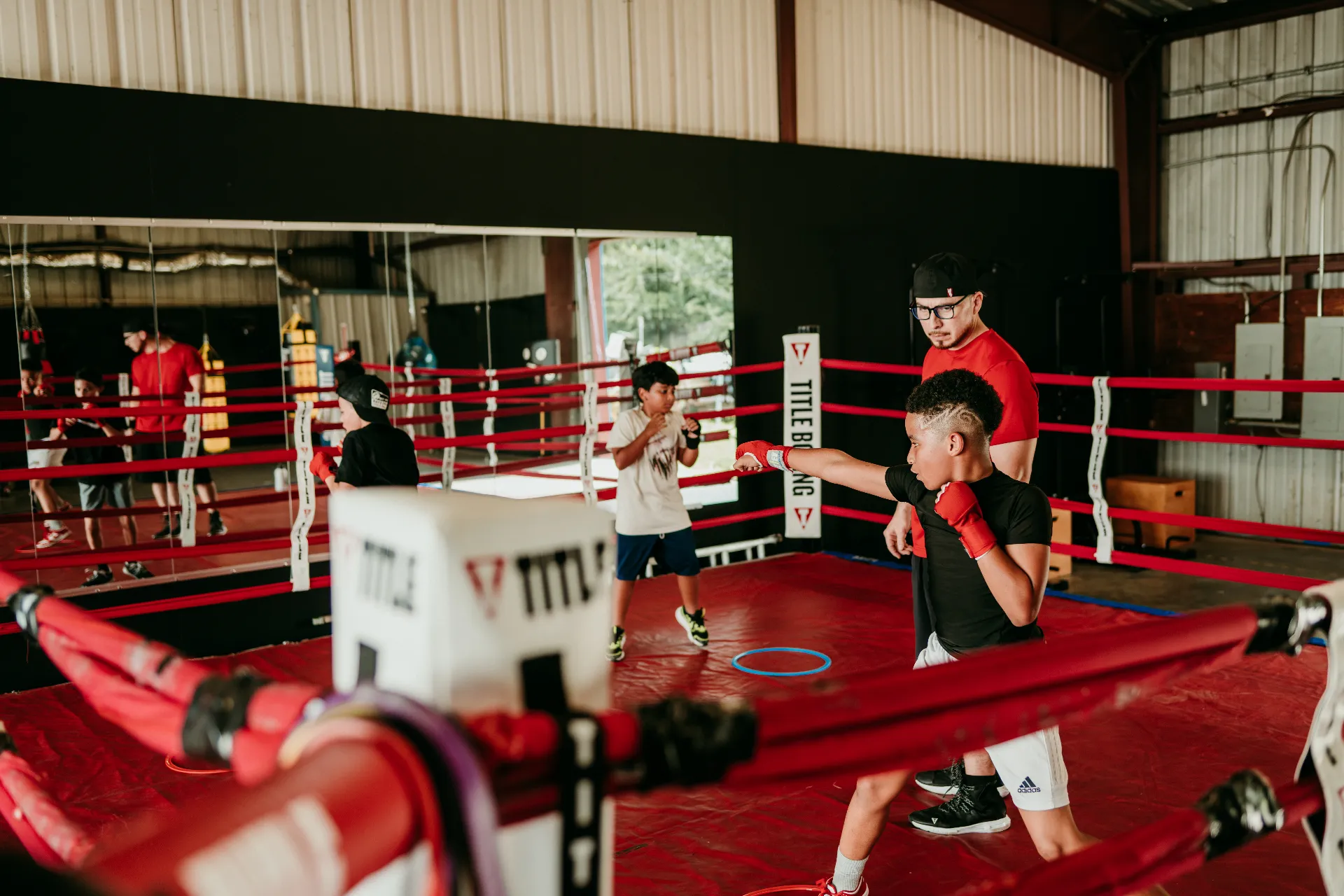 Coach Romo coaching young boxers during a group training session in the ring