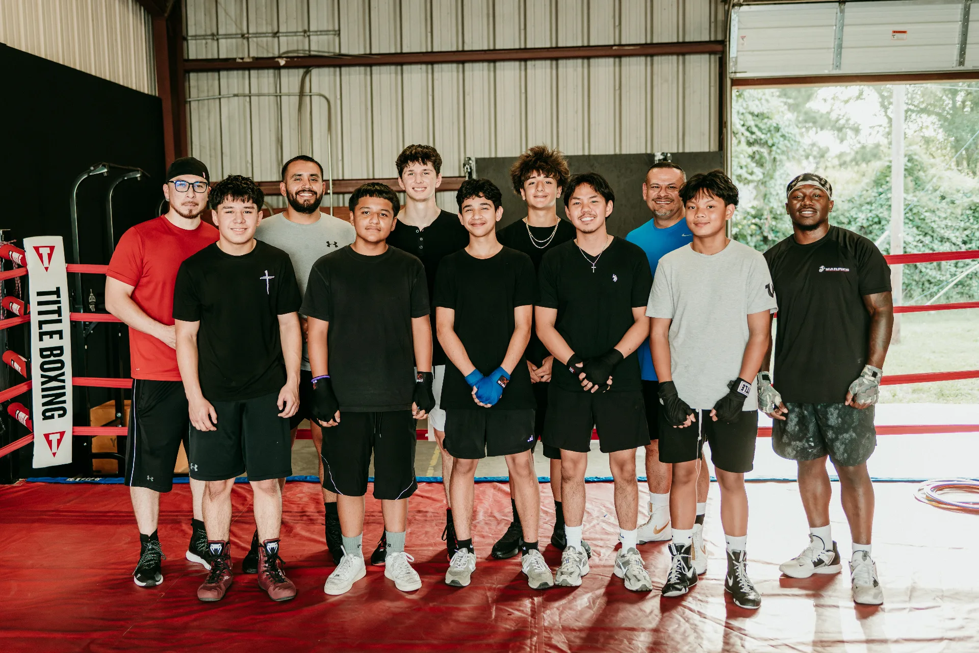 Group photo of Coach Romo, staff, and students inside One More Round Boxing Gym
